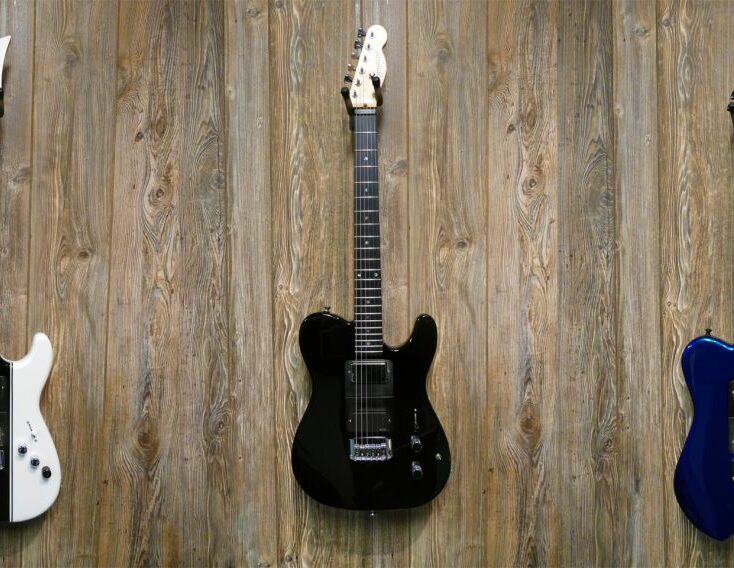 Three guitars hanging on the wall